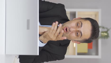 Vertical-video-of-Home-office-worker-man-applauding-what-he-sees-on-laptop.